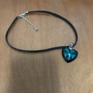 Beautiful faux suede choker with blue flower inside heart shaped glass pendant.